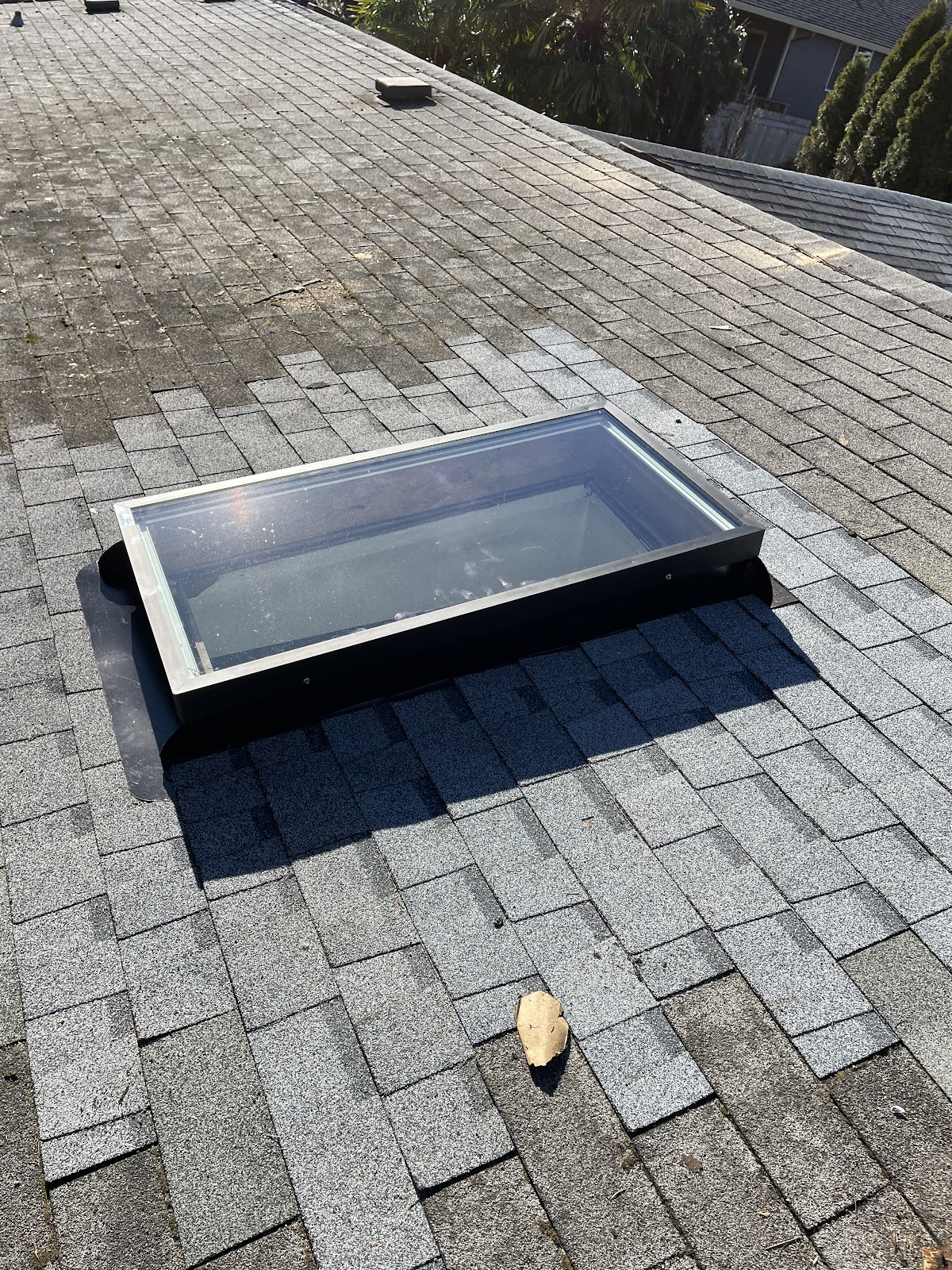 A skylight set cleanly into a fresh shingle roof by Tilly's Roofing